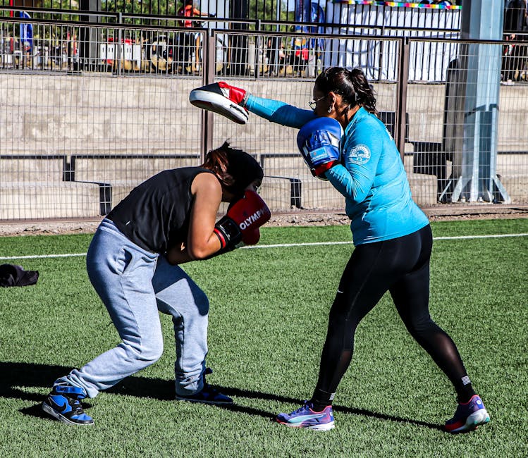 Two women engaged in a boxing training session outdoors, focusing on technique and endurance