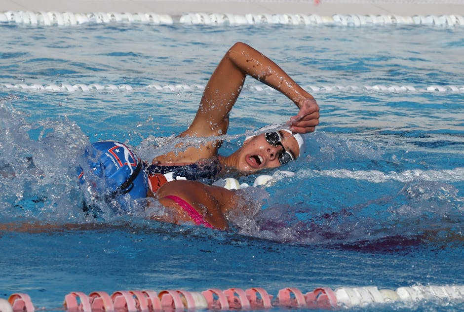Focused swimmer competes in breaststroke race at sunlit outdoor swimming pool
