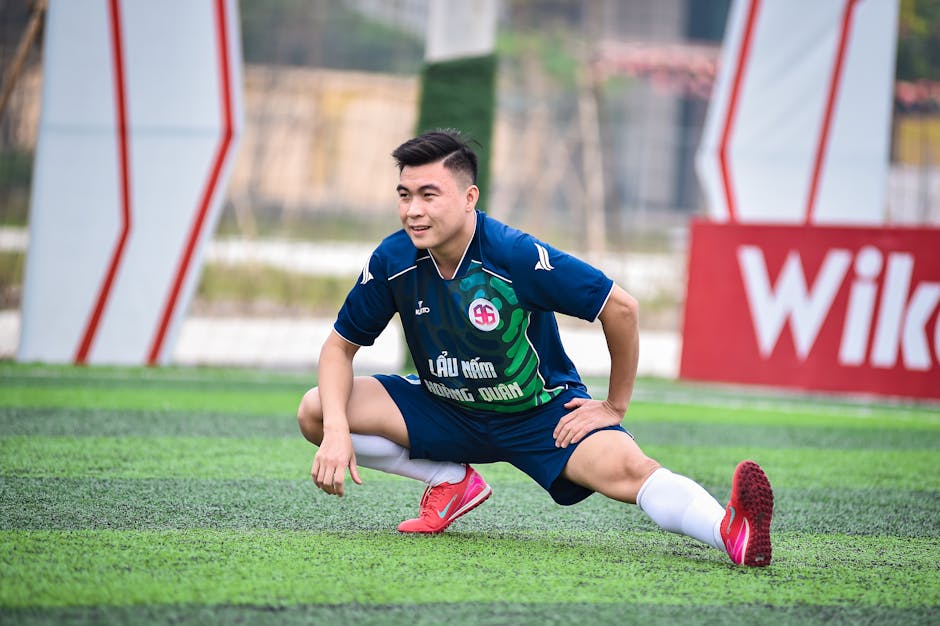 Football player stretching on artificial turf before a game in Hanoi, Vietnam